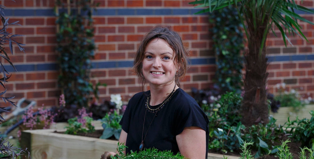 Anna Mortimer headshot taken by Luke MacGregor in front of a brick wall outdoors