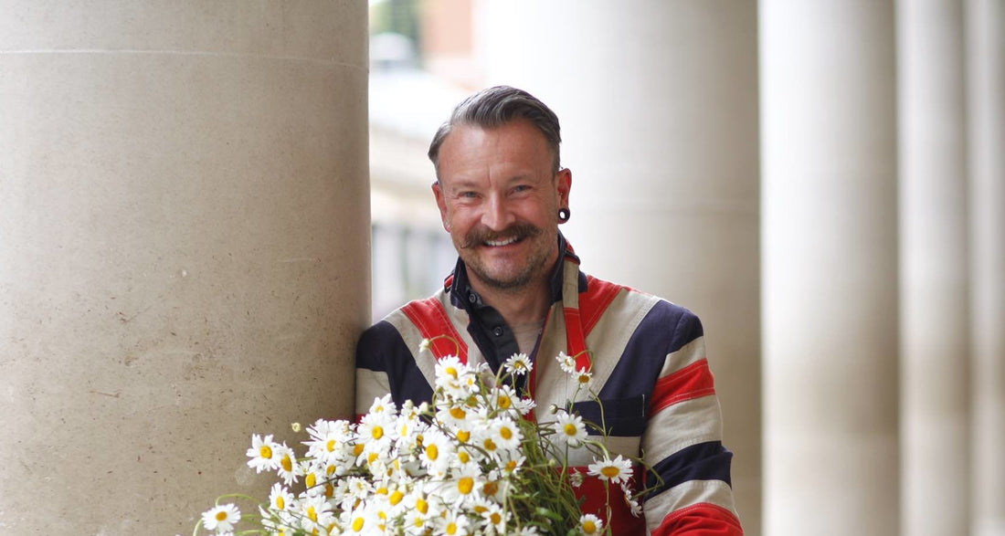 Simon Lycett posing with a white flower arrangement