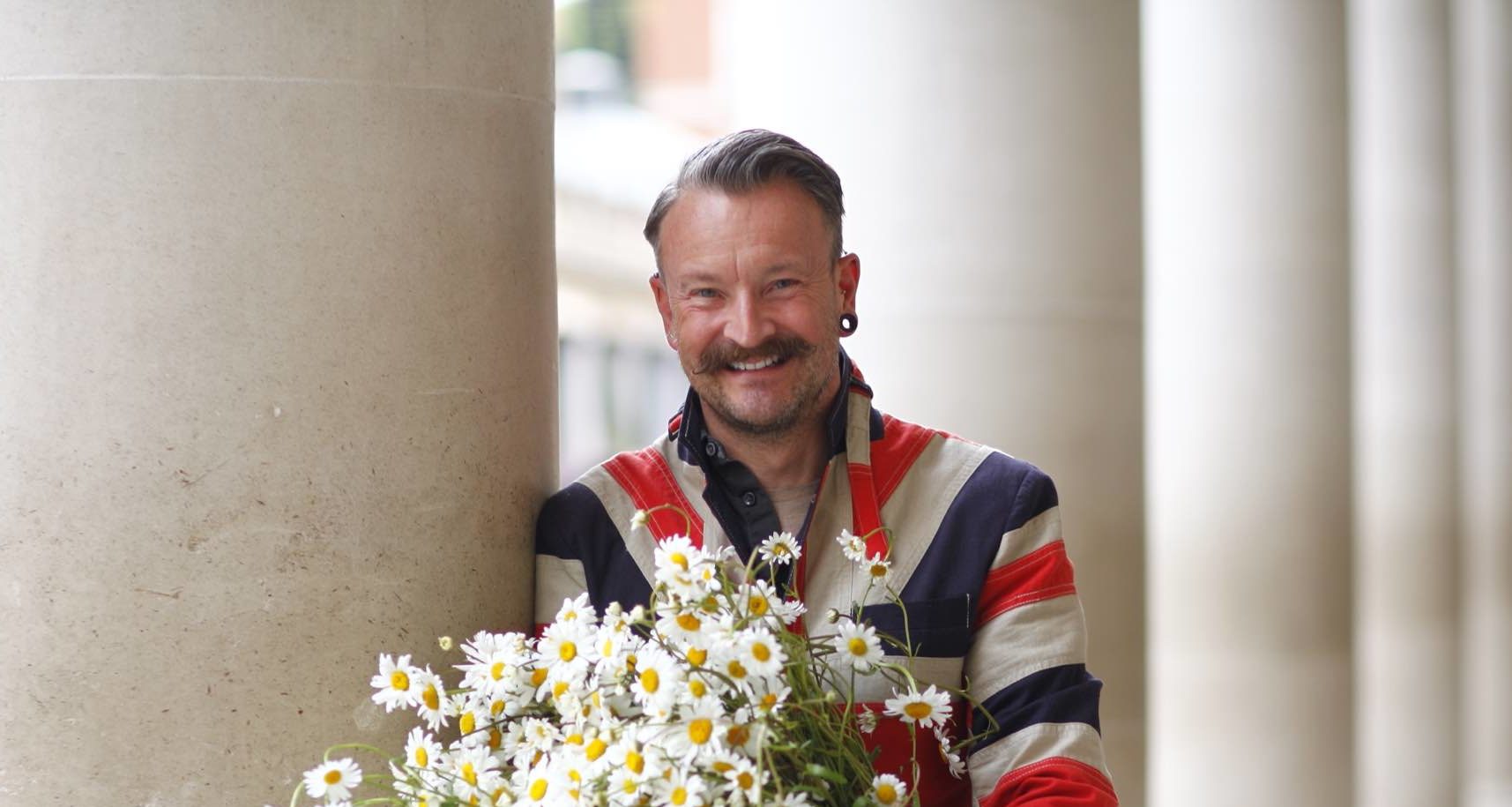 Simon Lycett posing with a white flower arrangement