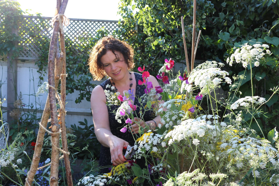 Naomi Slade tending to white-flowering plants in her garden
