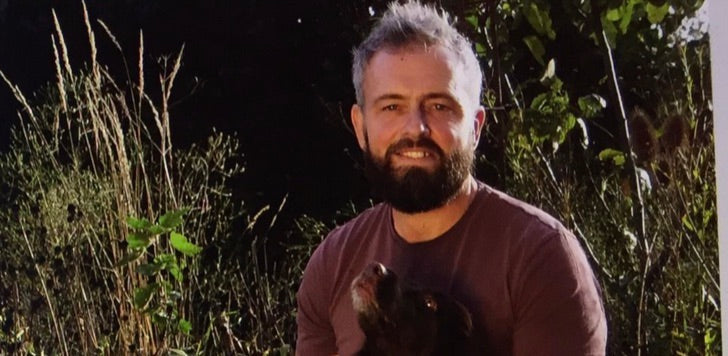 Paul Hervey-Brookes with his dog in a grassy garden