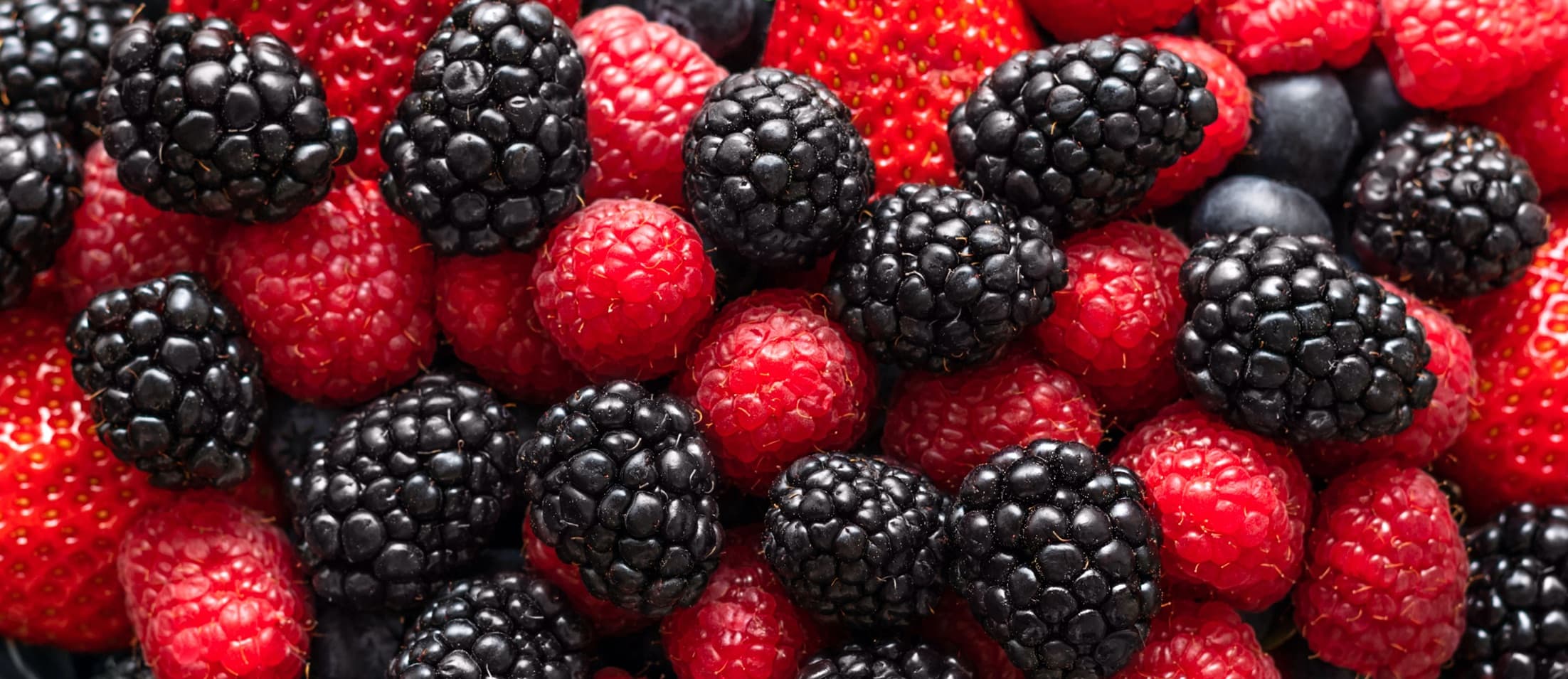blackberries, raspberries and strawberries on a mixed background