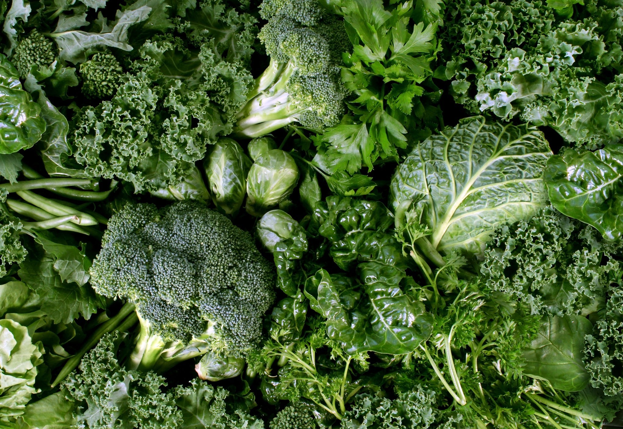 a variety of different green leafy vegetables including broccoli, cabbage and lettuce all lying next to each other