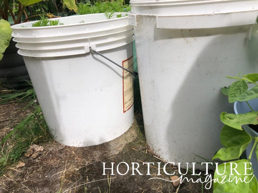 large white buckets sat in a garden