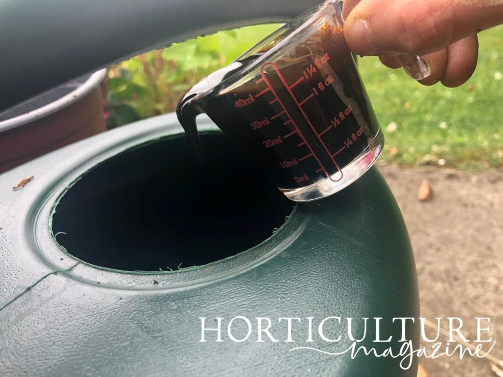 fertiliser being poured into a watering can