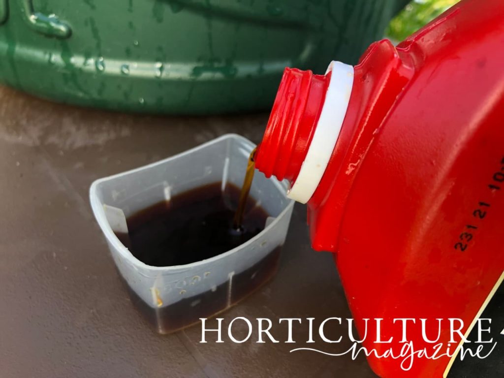a measurement of tomato plant feed being poured into a measuring container