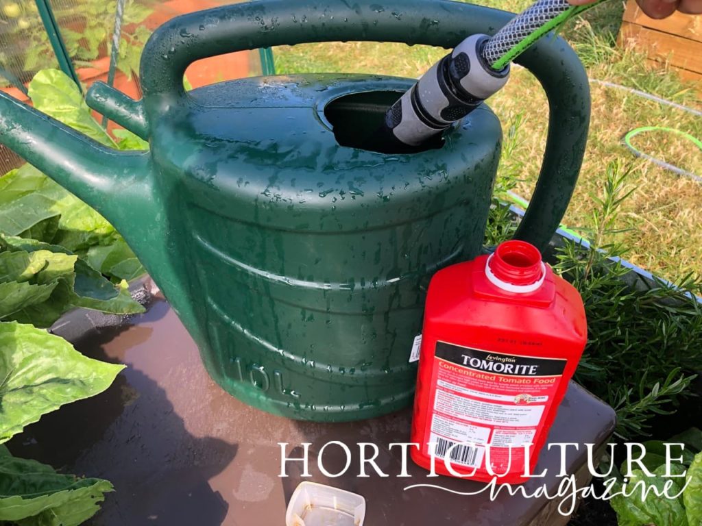 a hose being used to fill a watering can