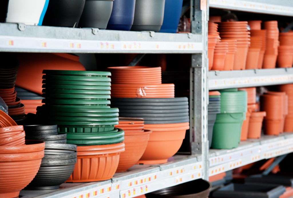 lots of various pots and containers in different colours and sizes stacked on metal shelves