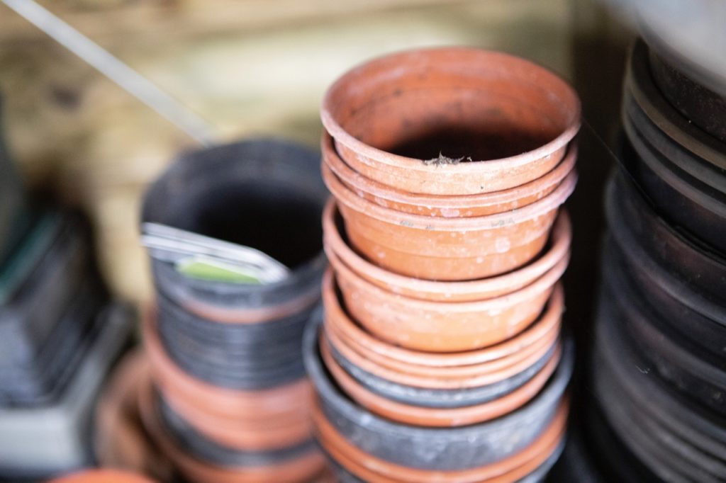 black and brown small garden pots stacked on top of one another inside in a shed