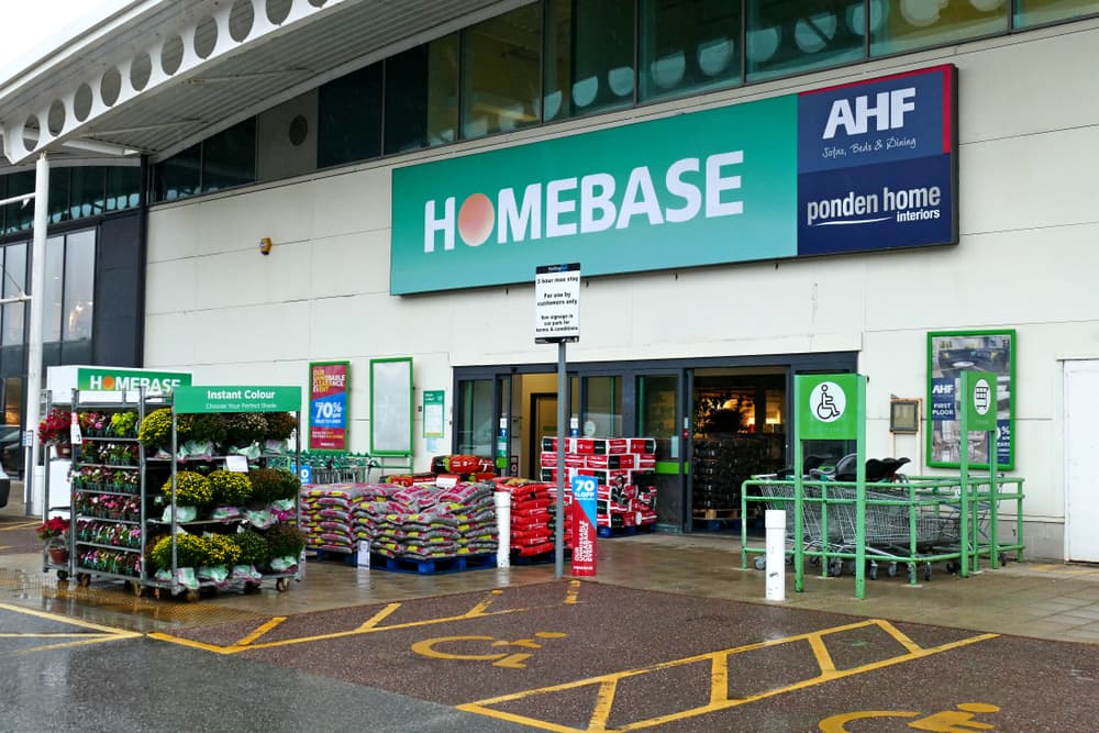 the outside of a homebase store with potted plants, bags of compost and trolleys