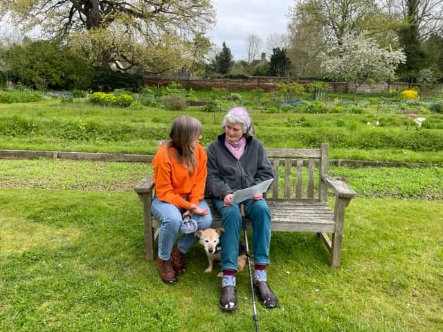 Sally Flatman interviewing Diana Boston outside on a garden bench