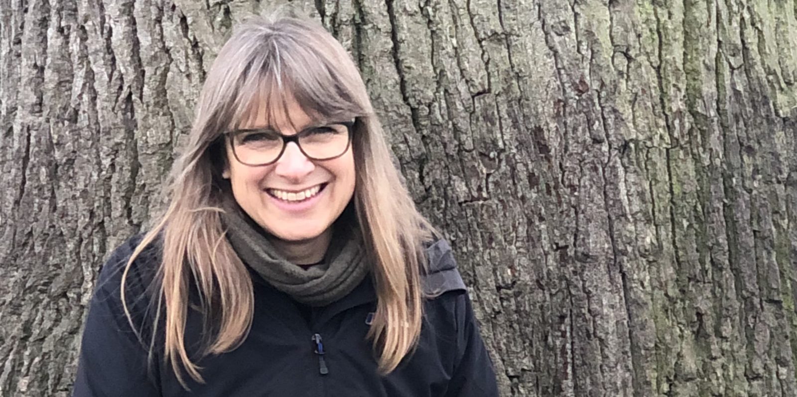 Sally Flatman smiling in front of a tree