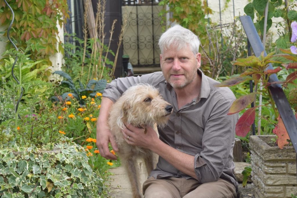 Ben with his dog Hazel in a floriferous garden