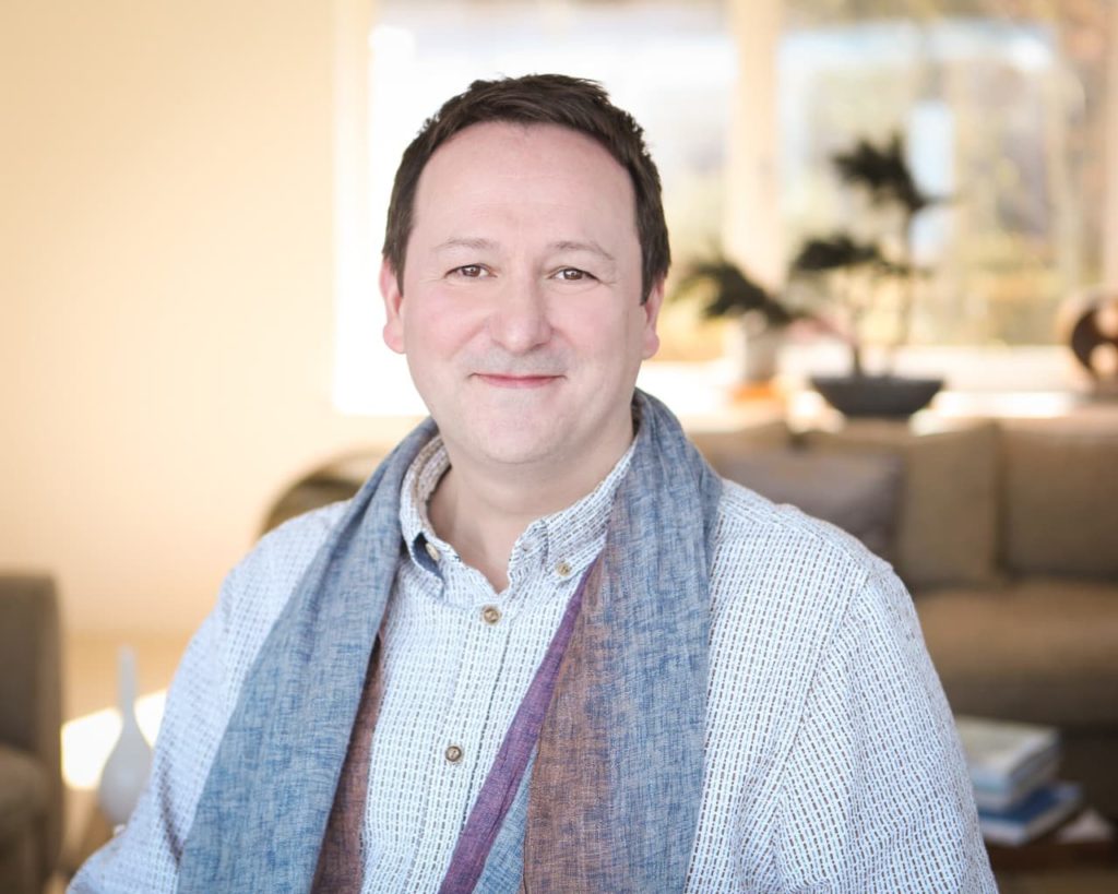 Gardener Mark Lane sitting indoors and smiling at the camera