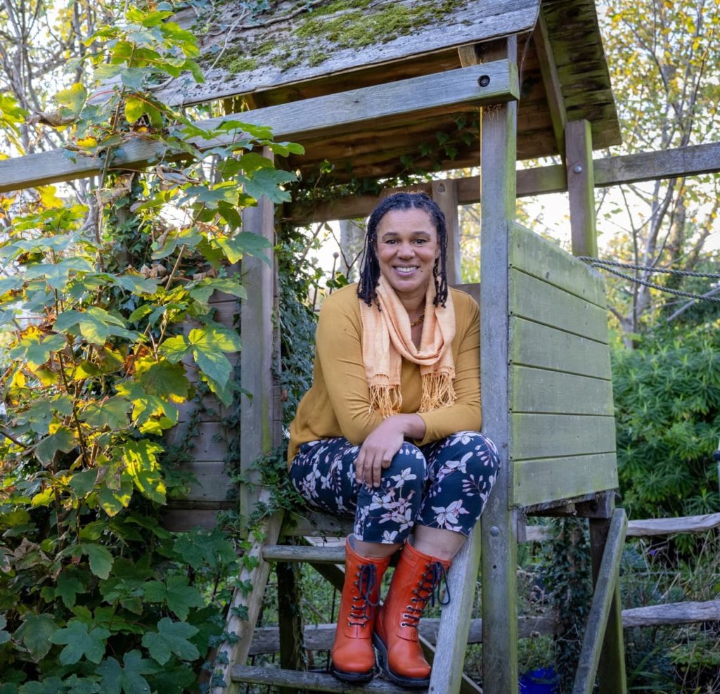 Juliet sat in a small treehouse surrounded by green foliage