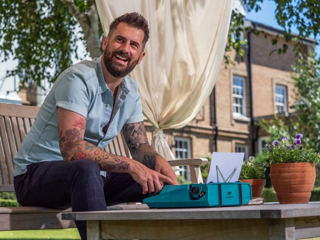 Michael Perry in the garden writing on a typewriter
