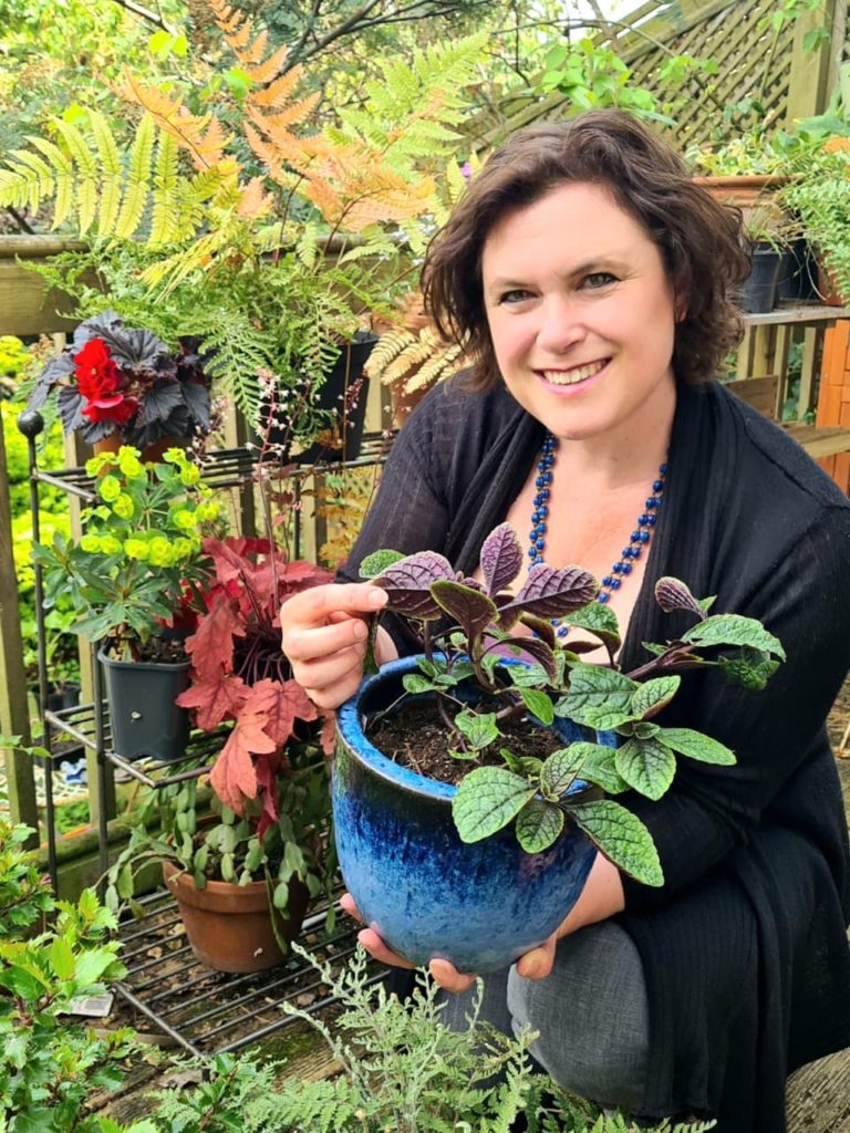Naomi Slade with a potted green and purple-leaved plants
