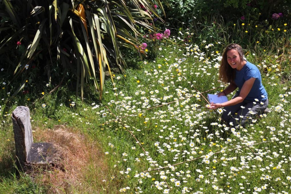 Debi Holland in a daisy-filled garden outdoors