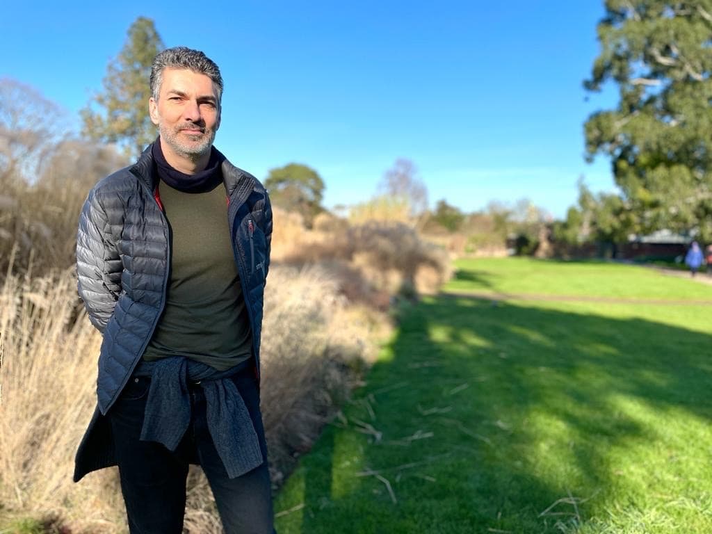 Wes Shaw stood in front of a large grassy field on a sunny day
