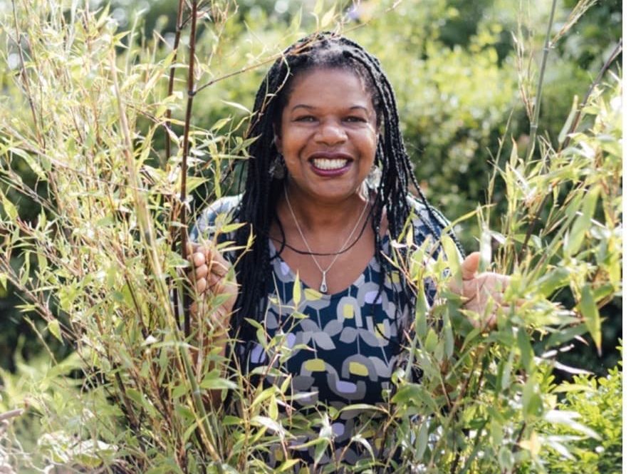 Jacquie Felix-Mitchell peeking through some tall grass