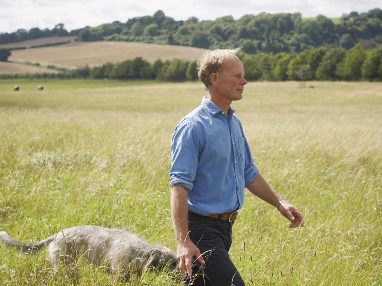 Kim Wilkie in a grassy field with his dog