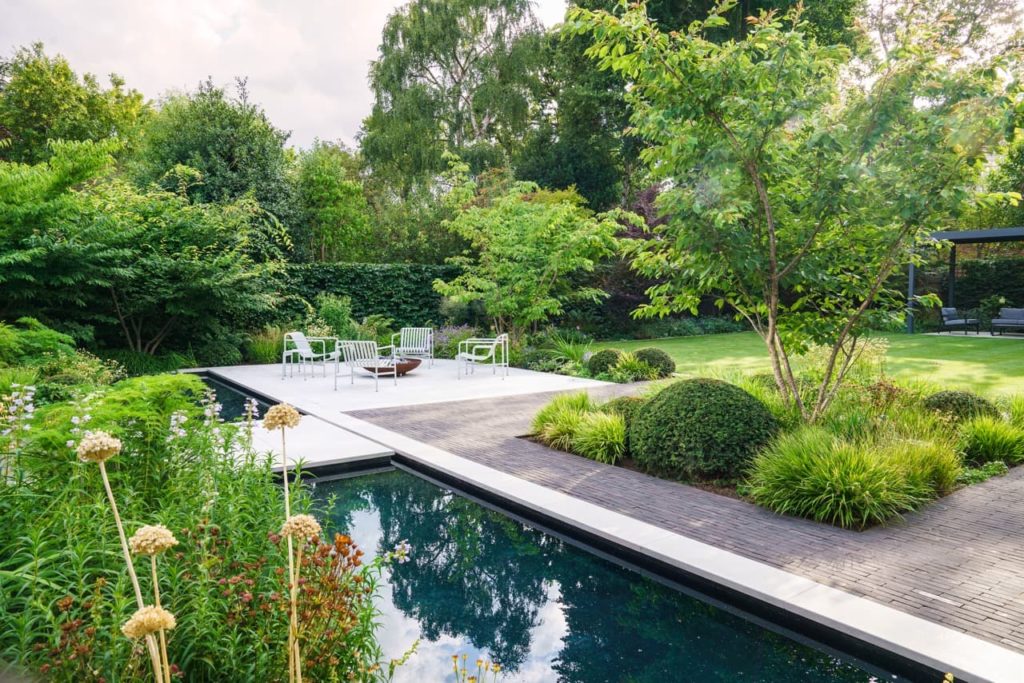 a Tom Simpson designed garden with a rectangular pond, lots of grasses and a patio area