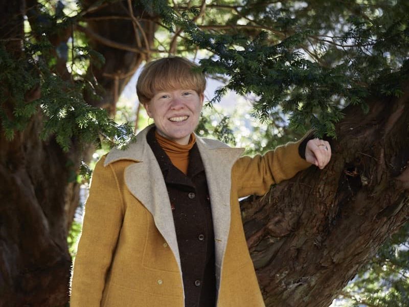 Gemma Jerome stood amongst trees in her garden
