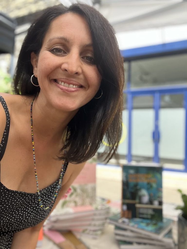 Sonya Patel Ellis posing with some of her books at a publishing event