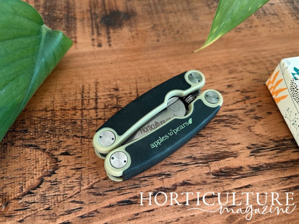 folded black and sage green secateurs with horticulture.co.uk engraved onto the blade