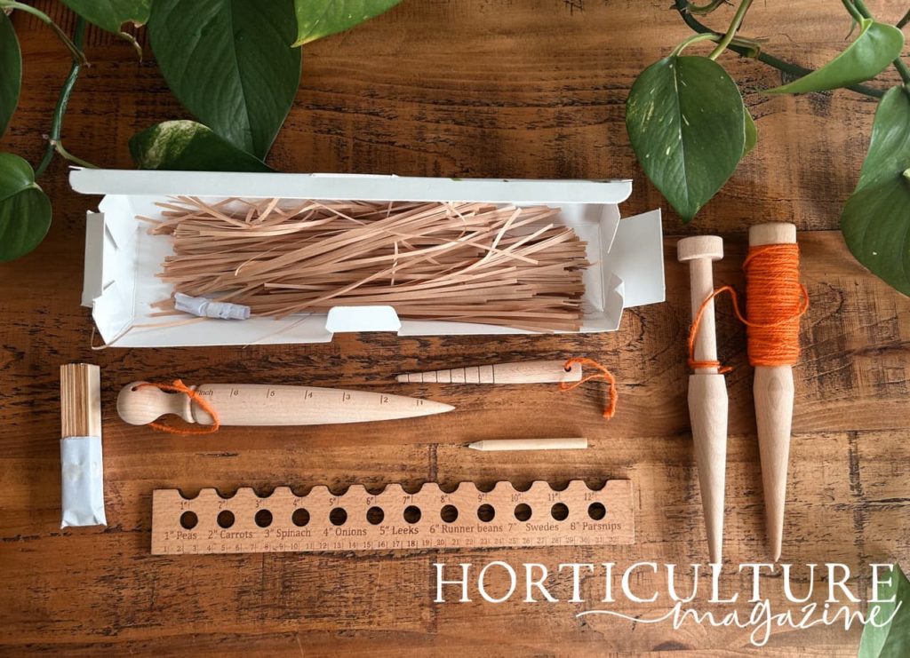 a planting line, dibbers, a pencil, a ruler and some plant labels next to the Evanmore packaging they came in