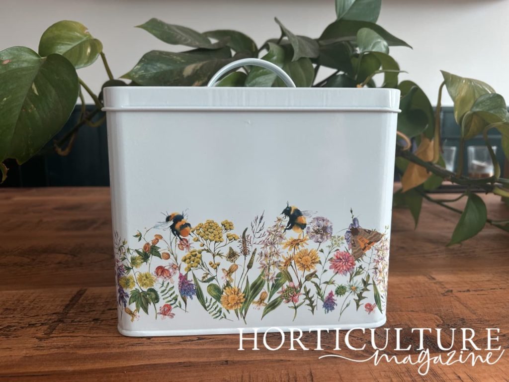 an illustration of bees and colourful flowers printed onto a metal seed box