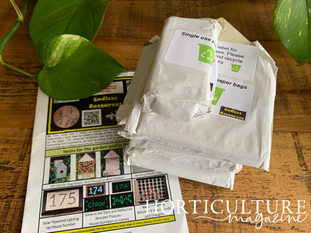 the paper bags containing the parts to the DIY hotel next to the instruction manual