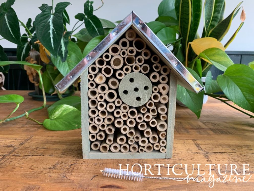 Garden Locker wild bee house with cleaning brush shown in the foreground