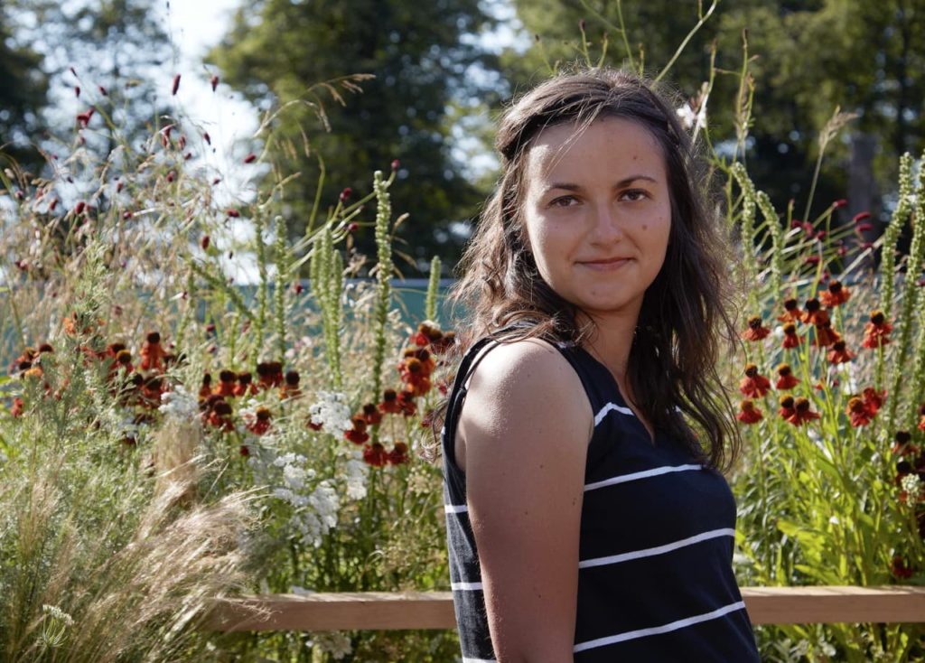 anca panait in a garden with long grasses and heleniums in the background