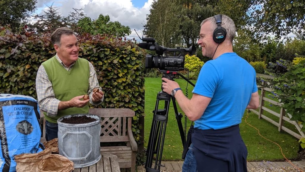 Martin filming some content for his YouTube channel with a large container full of compost