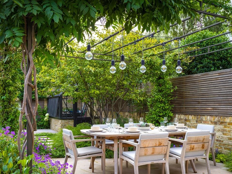 outdoor dining area designed by Chris Harrington surrounded by an array of plants on a patio