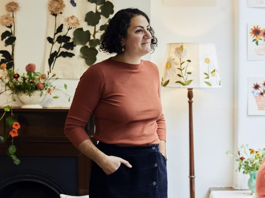 Lora Avedian inside a room decorated with botanical art