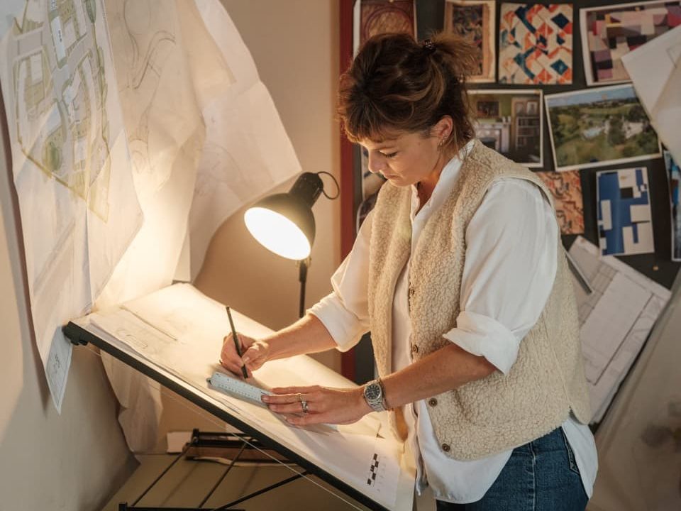 Lottie Delamain drawing on a design sketch pad indoors