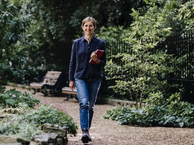 Non walking in a garden with a notebook