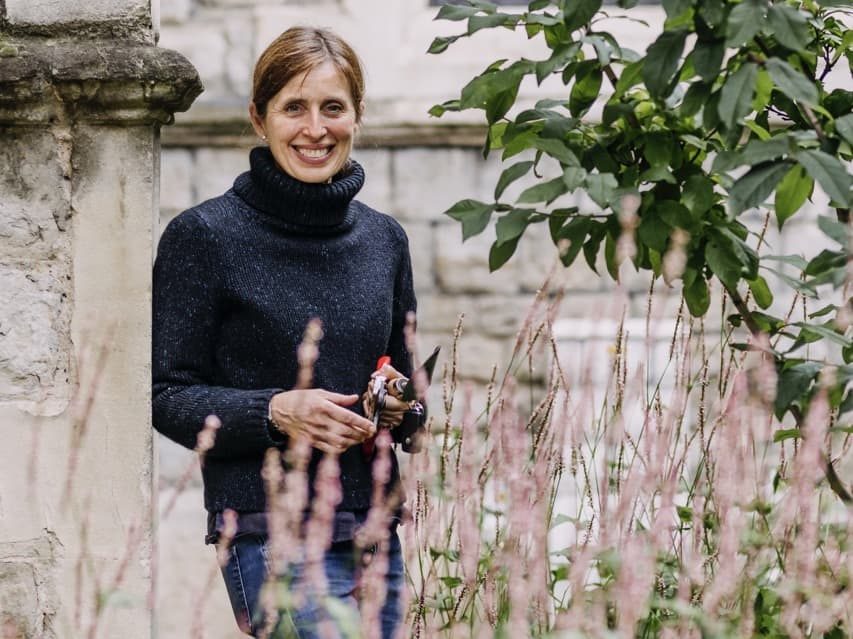 Non Morris posing in a garden with a pair of secateurs in her hands