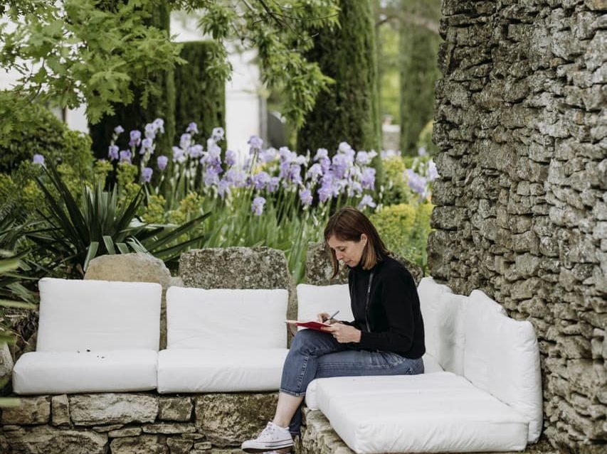 Non writing some content in a book for a magazine on a seated area outside
