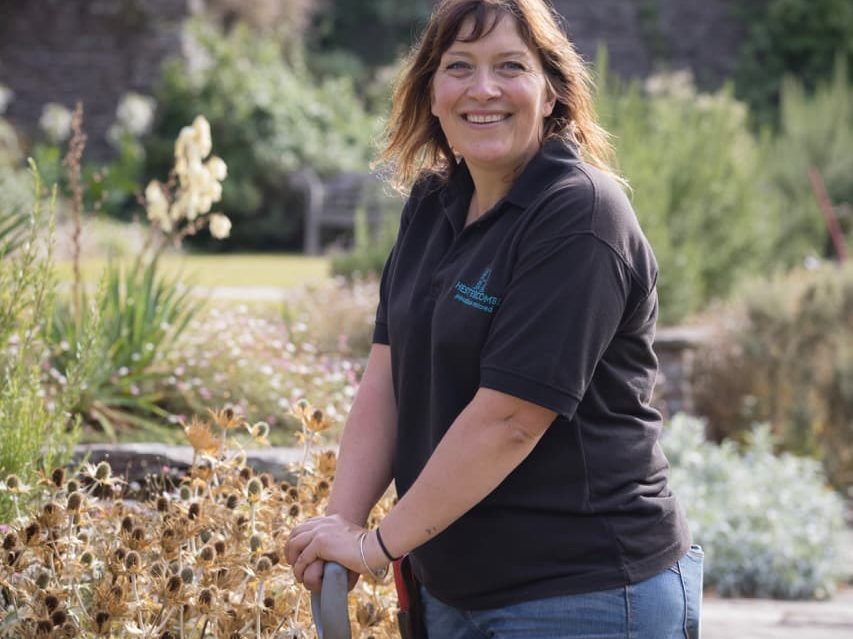 Claire Greenslade out in the garden with a shovel ready to do some work on the borders
