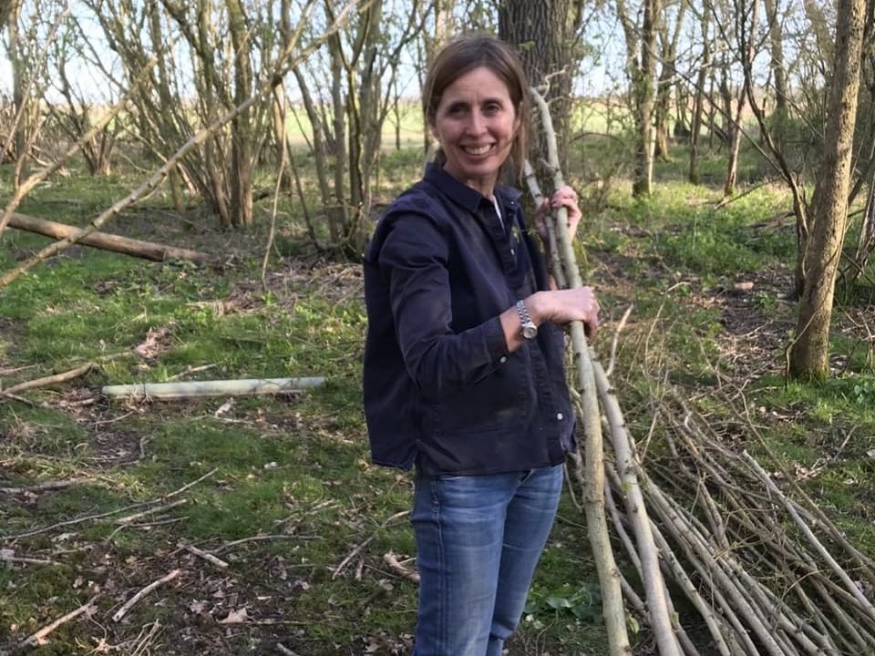 Non Morris collecting branches of hazel in a woodland area