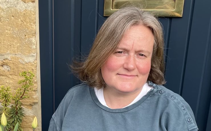 headshot of Kate Burtonwood taken in front of a dark blue door