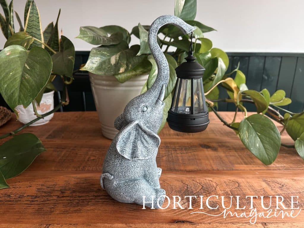 elephant statue holding up a solar-powered lantern with its trunk