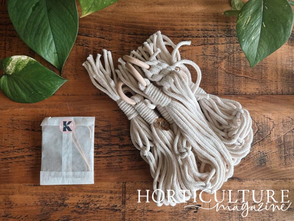 mini plant hangers from Knotted Studio with hooks in a paper envelope next to it