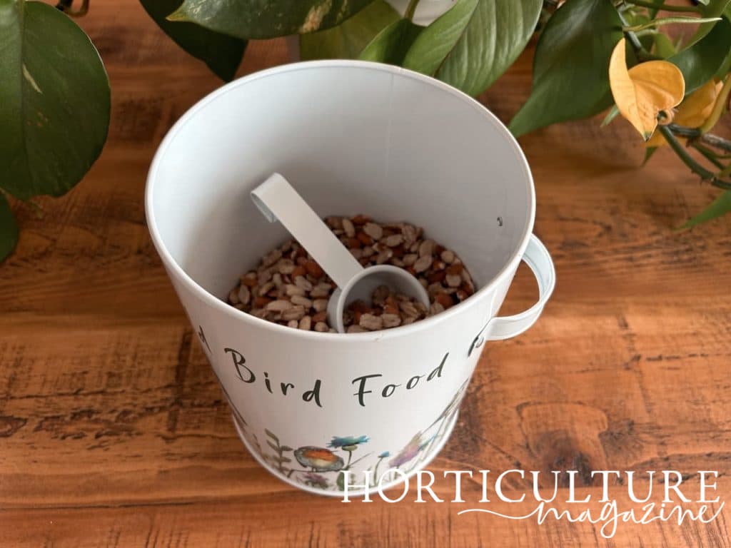 bird feed inside a tin with a scoop inside ready for use