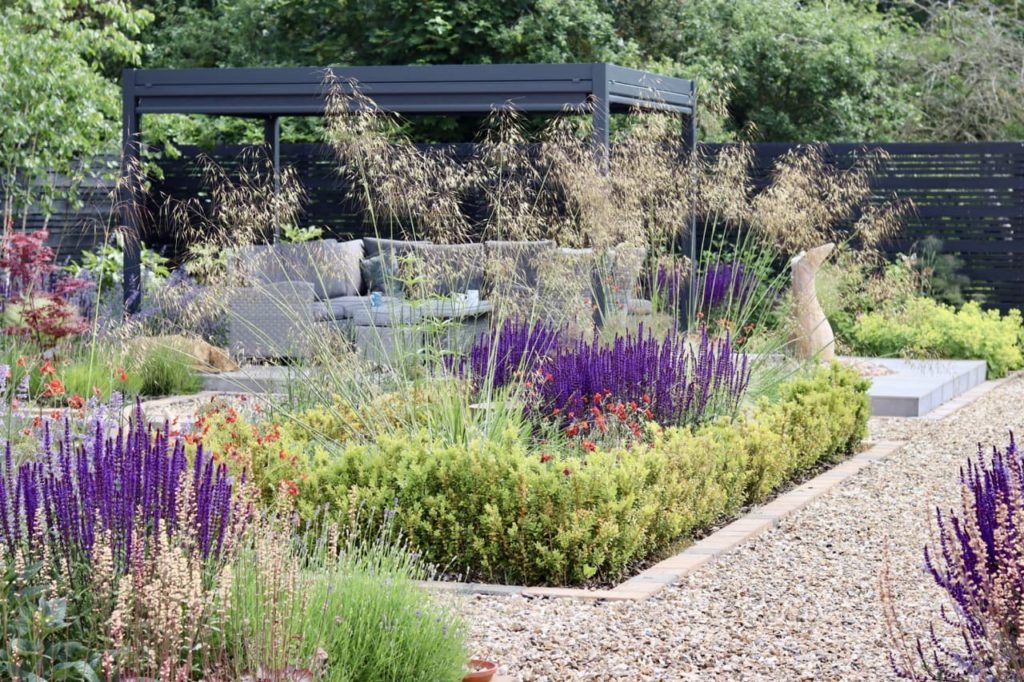 formal garden borders with colourful purple and red flowers surrounded by gravel paths - garden designed by Ian McBain