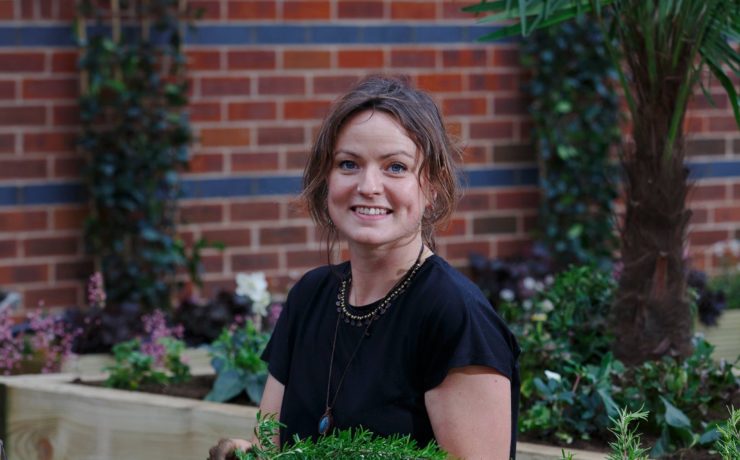 Anna Mortimer headshot taken by Luke MacGregor in front of a brick wall outdoors