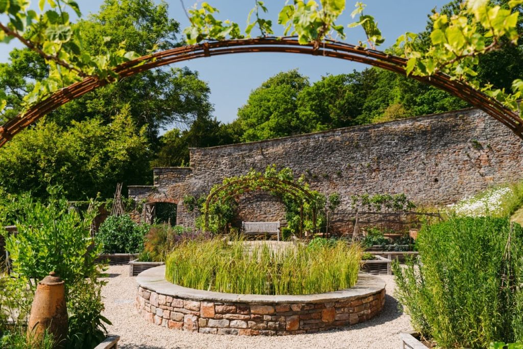 the estate at Belmont with lots of raised beds filled with greenery in front of a brick wall